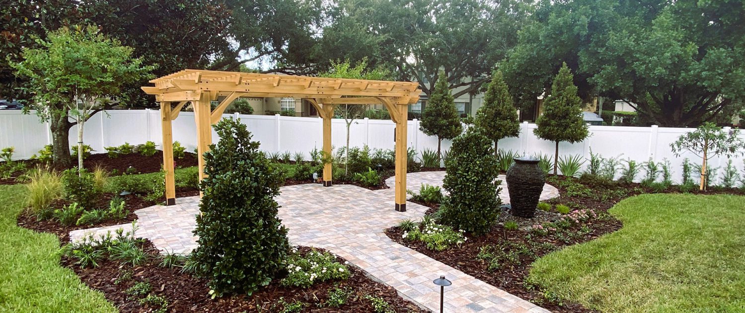 Custom pergola with paver patio, landscape lighting, and garden landscaping design in the Orlando Florida area Custom pergola with paver patio, landscape lighting, and garden landscaping design in the Orlando Florida area