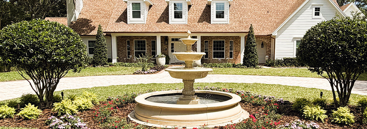 Estate home with landscaped front yard, circular driveway, and decorative fountain in Orlando, Florida