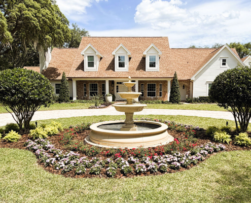 Estate home with landscaped front yard, circular driveway, and decorative fountain in Orlando, Florida