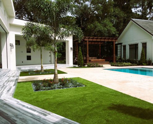 Luxury outdoor living design on an Orlando estate featuring integrated pool, pergola, modern patio, and structured landscape layout