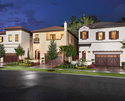 File Name:\ `orlando-residential-landscape-design-evening-lighting.jpg` Alt Tag:\ `Orlando residential landscape design featuring three Mediterranean-style homes with manicured lawns, palm trees, ornamental plantings, and landscape lighting at dusk.`