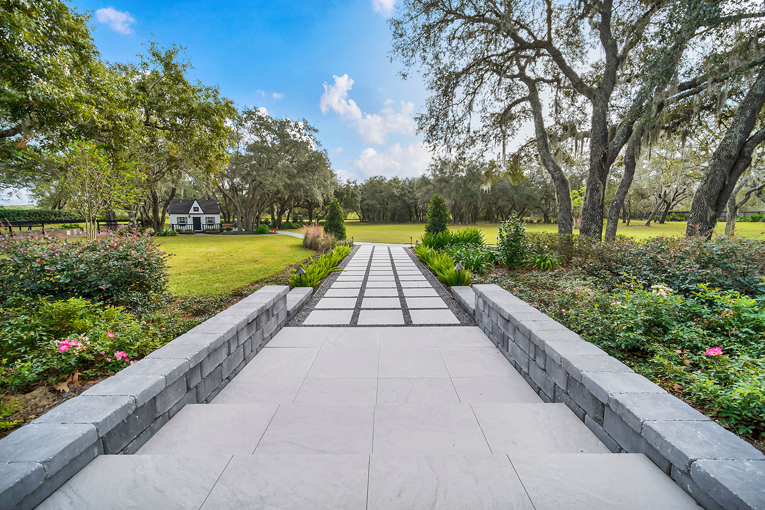 Property-wide landscape modernization featuring integrated hardscape, mature landscaping, circulation pathways, and cohesive estate landscape design Property-wide landscape modernization featuring integrated hardscape, mature landscaping, circulation pathways, and cohesive estate landscape design
